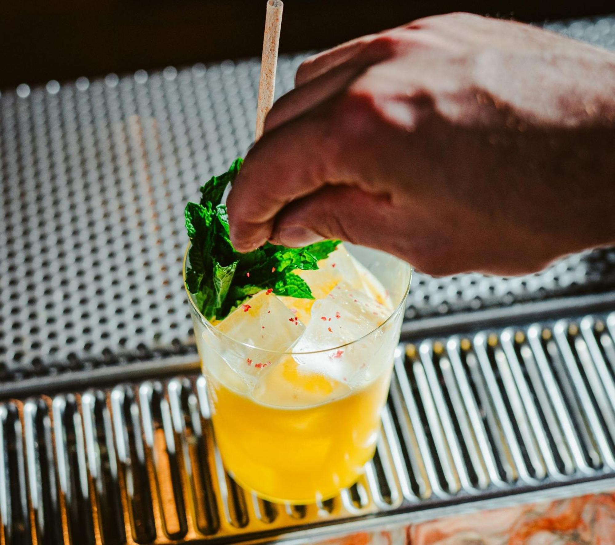 Vignette Collection Yours Truly Dc By Ihg Washington Ngoại thất bức ảnh A bartender garnishes a cocktail with mint.